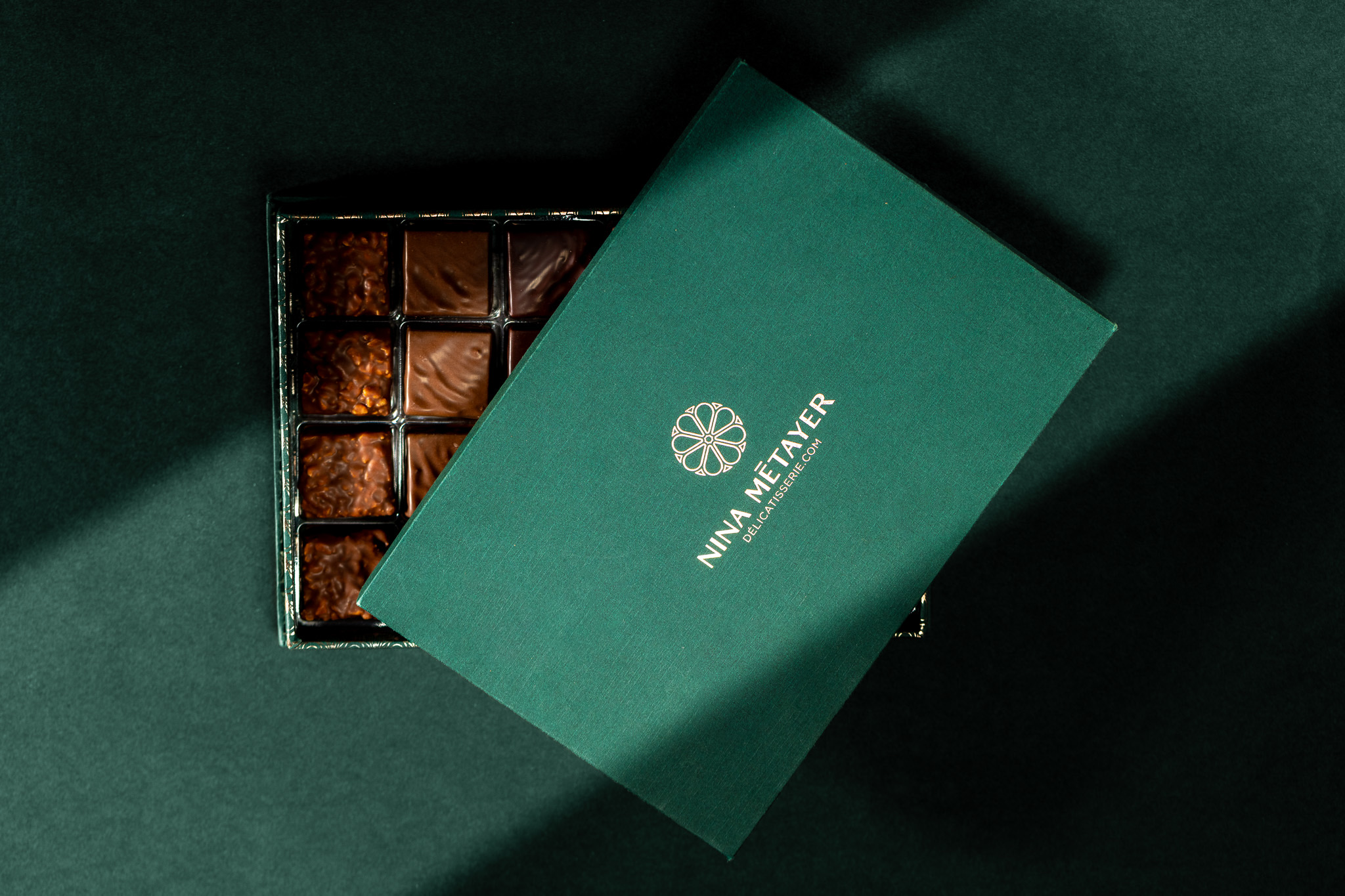 Coffret vert Nina Métayer entrouvert sur ses chocolats